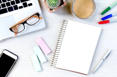 Üst görünümde çalışmak ve uzayı kopyalamak için bir sürü ekipman içeren beyaz ahşap ofis masası..