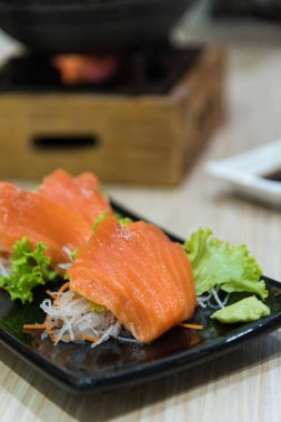 Somon balığı siyah plaka üzerinde hizmet için hazır vardır.