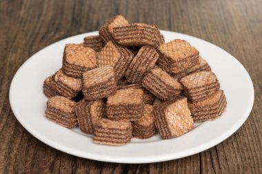 Beyaz plaka ve ahşap arka planda çikolata Wafers.