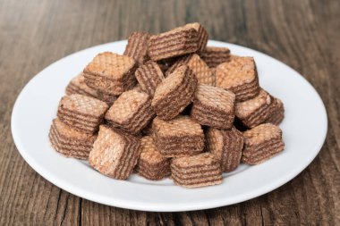 Beyaz plaka ve ahşap arka planda çikolata Wafers.
