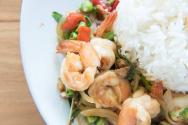 Tavada kızartılmış karides ve fesleğen pirinç Tay gıda tarzı vardır hazır için hizmet üzerinde plaka beyaz.