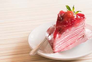 Beyaz tabakta çilekli kek, ahşap üzerine yakın çekim manzaralı ve sabah servis yapmaya hazır..