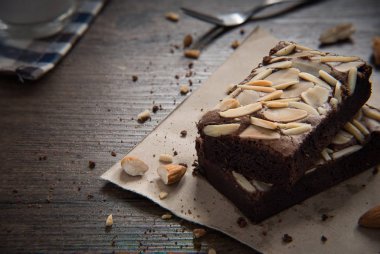 Çikolatalı badem Brownie ahşap masa üzerinde hizmet için hazır vardır.