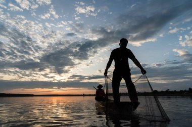 Wanon Niwat bölge Sakon Nakhon kuzeydoğu Tayland günbatımı zamanı net balıkçılık atma balıkçılar silüeti.