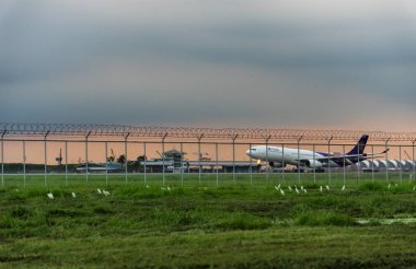Bangkok, Tayland-Ağustos 19, 2017: Tay havayolu Bangkok Tayland Suvarnabhumi Havaalanı gün batımı manzarası ile akşamları bulutlu gökyüzü altında çıkar sonra.