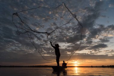 Wanon Niwat bölge Sakon Nakhon kuzeydoğu Tayland günbatımı zamanı net balıkçılık atma balıkçılar silüeti.