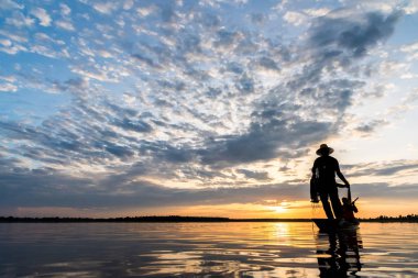 Wanon Niwat bölge Sakon Nakhon kuzeydoğu Tayland günbatımı zamanı net balıkçılık atma balıkçılar silüeti.