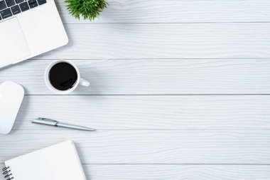 Beyaz ahşap ofis masası ve ekipman. Sade kahve ve düz ışın konseptiyle çalışmak için..