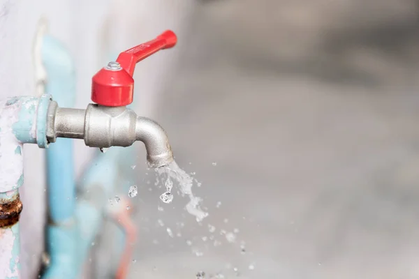Closeup Tap with dripping water-drop. Saving water.