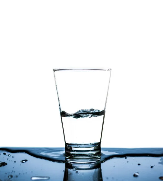 Vaso Agua Bebía Por Medio Vaso Agua Salpicaba Sobre Mesa —  Fotos de Stock