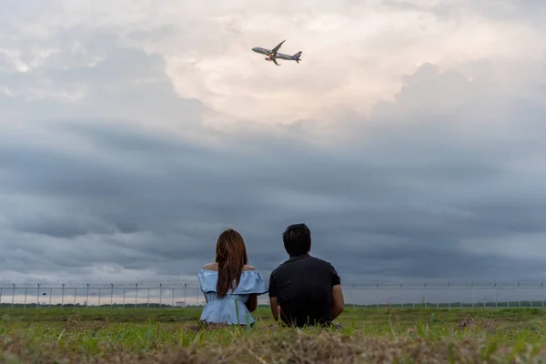 男と女の子は青空と日没時間と夕方に緑の庭から飛行機を見て楽しむ — ストック写真