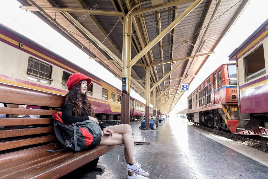 Asian woman traveler has sitting and waiting the train at Hua Lamphong station at Bangkok, Thailand.