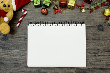 Noel ayısı ve beyaz kitap. Kahverengi ahşap masa üzerindeki boşluğu kopyalayın. Noel festivali konsepti.