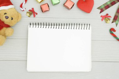 Noel ayısı ve beyaz kitapla beyaz ahşap masadaki boşluğu kopyalayın. Noel tatili kavramı.