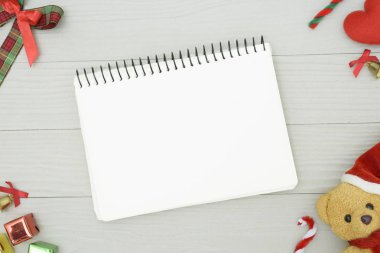 Noel ayısı ve beyaz kitapla beyaz ahşap masadaki boşluğu kopyalayın. Noel tatili kavramı.