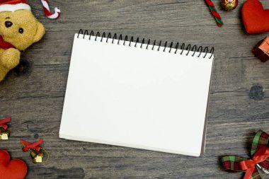 Noel ayısı ve beyaz kitap. Kahverengi ahşap masa üzerindeki boşluğu kopyalayın. Noel festivali konsepti.