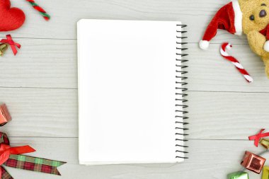 Noel ayısı ve beyaz kitapla beyaz ahşap masadaki boşluğu kopyalayın. Noel tatili kavramı.