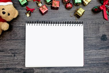 Noel ayısı ve beyaz kitap. Kahverengi ahşap masa üzerindeki boşluğu kopyalayın. Noel festivali konsepti.