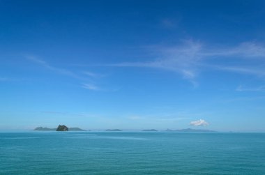 Sabahları mavi gökyüzünün altında deniz manzarası.