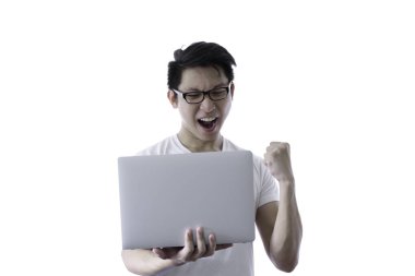 Beyaz gömlek ve turuncu gözlük ile Asyalı yakışıklı adam mutlu ve bir kazanan gibi duygu zaman tutarak ve hedef için bilgisayar dizüstü bilgisayar ile çalışan ve başarılı beyaz arka plan ve kırpma yolları izole.