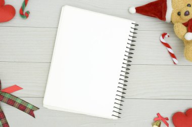 Noel ayısı ve beyaz kitapla beyaz ahşap masadaki boşluğu kopyalayın. Noel tatili kavramı.