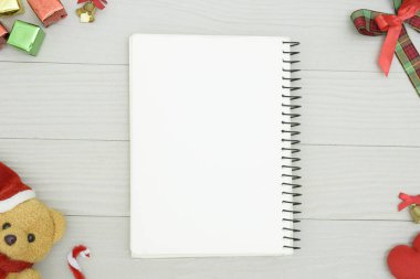 Noel ayısı ve beyaz kitapla beyaz ahşap masadaki boşluğu kopyalayın. Noel tatili kavramı.