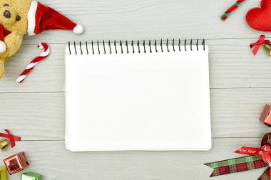 Noel ayısı ve beyaz kitapla beyaz ahşap masadaki boşluğu kopyalayın. Noel tatili kavramı.