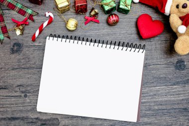 Noel ayısı ve beyaz kitap. Kahverengi ahşap masa üzerindeki boşluğu kopyalayın. Noel festivali konsepti.