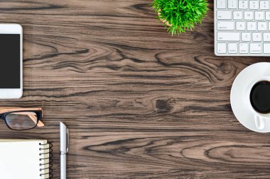 Kahverengi ahşap ofis masası ve çalışma ve dinleme ekipmanları beyaz kulaklıklı üst görünümde ve boşluğu kopyalamak için.