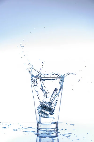 Jégcsepp Víz Fröccsenés Üvegben Tükröződés Tükörasztalon Elszigetelt Fehér Alapon — Stock Fotó