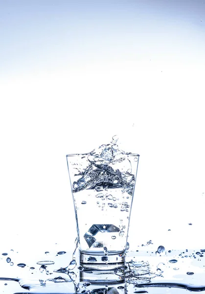 Ghiaccio Spruzzi Acqua Nel Bicchiere Con Riflessione Sul Tavolo Degli — Foto Stock