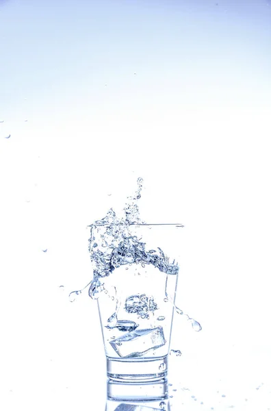 冰滴和水飞溅在玻璃上 镜面桌上反射 白色背景隔离 — 图库照片