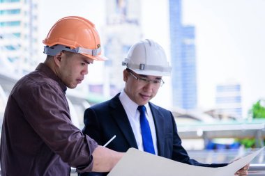 İki Asyalı iş adamı ve mühendis tasarım bürosu ve şehir için planlama ve çalışma yapıyor..