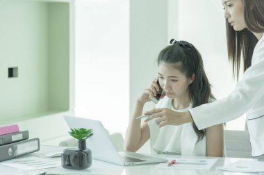 İş kadını yöneticisinin, yeni çalışanlar için ciddi ve ciddi bir şekilde ofis içinde çalışmak üzere öğretmenliği var..