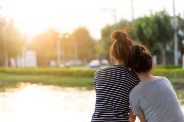 Bahçe parkında ve nehirde gün batımını seyreden bir çift aşık olur..