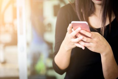 Bir iş kadınının cep telefonunda müşterisiyle çalışmak ve iletişim kurmak için e-postaları vardır..