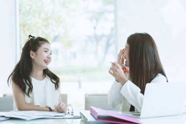 Ofisin içinde mutlu ve güler yüzlü kadınlar birlikte çalışıyor..