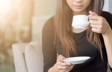 Asain bir iş kadını iş arkadaşıyla ofiste bir fincan kahve içer..