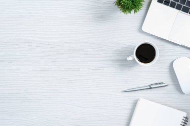 Beyaz ahşap ofis masası ve ekipman. Sade kahve ve düz ışın konseptiyle çalışmak için..