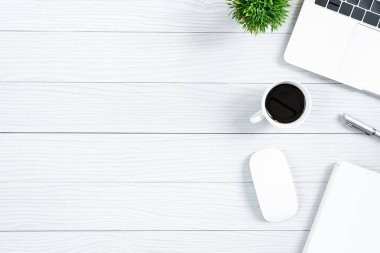 Beyaz ahşap ofis masası ve ekipman. Sade kahve ve düz ışın konseptiyle çalışmak için..