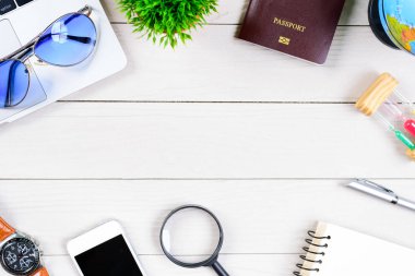 Çalışan ve çalışan masası düz bir manzaradan beyaz ahşap masa üzerinde dizüstü bilgisayar ve pasaportla seyahat etmeye hazırlanıyor ve hayal kuruyor..