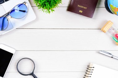 Çalışan ve çalışan masası düz bir manzaradan beyaz ahşap masa üzerinde dizüstü bilgisayar ve pasaportla seyahat etmeye hazırlanıyor ve hayal kuruyor..