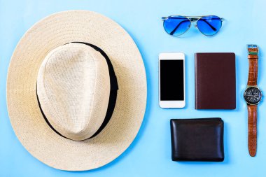 Beyaz şapka, mavi gözlük, telefon, saat, boş pasaport ve mavi arka planda izole kahverengi cüzdan ile yaz seyahati konsepti.