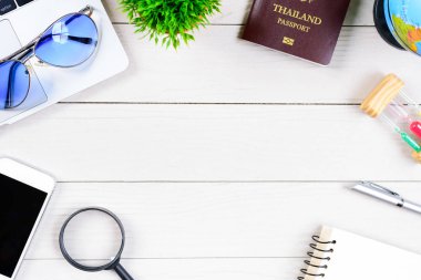 Taylandlı işçi ve çalışan masası, düz bir manzaradan beyaz ahşap masaya dizilmiş dizüstü bilgisayar, Tayland ve pasaportla seyahat etmeye ve seyahat etmeye hazırlanıyor..
