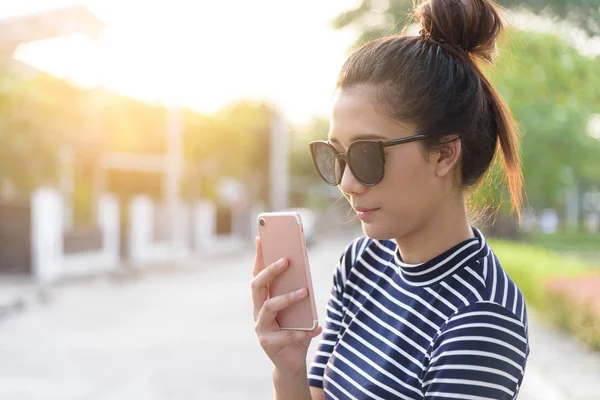 Güzel bir kadının akşamları bahçe parkında ve nehirde günbatımı saatinde telefon ve selfie 'si olur..