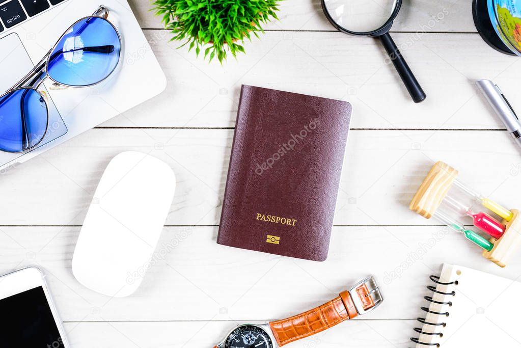 The worker and employee desk has trip dreaming and preparing to journey and travel around the world with laptop and passport on white wood table from flat lay top view.