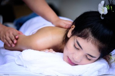 Güzel Asyalı insanların portresi. Kapalı görüşlü, gözlerini kapatan ve kaplıca salonunda el masajı yaptıran. Güzellik, sağlık, kaplıca ve rahatlama konsepti.