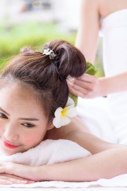 Güzel Asyalı insanların portresi. Kapalı görüşlü, gözlerini kapatan ve kaplıca salonunda el masajı yaptıran. Güzellik, sağlık, kaplıca ve rahatlama konsepti.