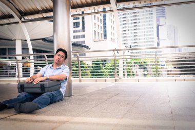 Depresyonda olan siyah çantalı bir iş adamı..