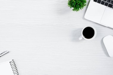 Beyaz ahşap ofis masası ve ekipman. Sade kahve ve düz ışın konseptiyle çalışmak için..